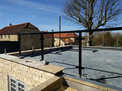 Ext. Day. Pub. Beginning construction of the edge-protection glazed screen for the flat roof.