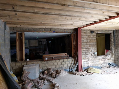 Int. Day. Pub. The removal of the existing, formerly exterior, windows —  thereby creating access into the newly built room.