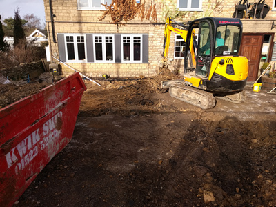 Exterior. Day. Pub with digging machine at work - closer shot.